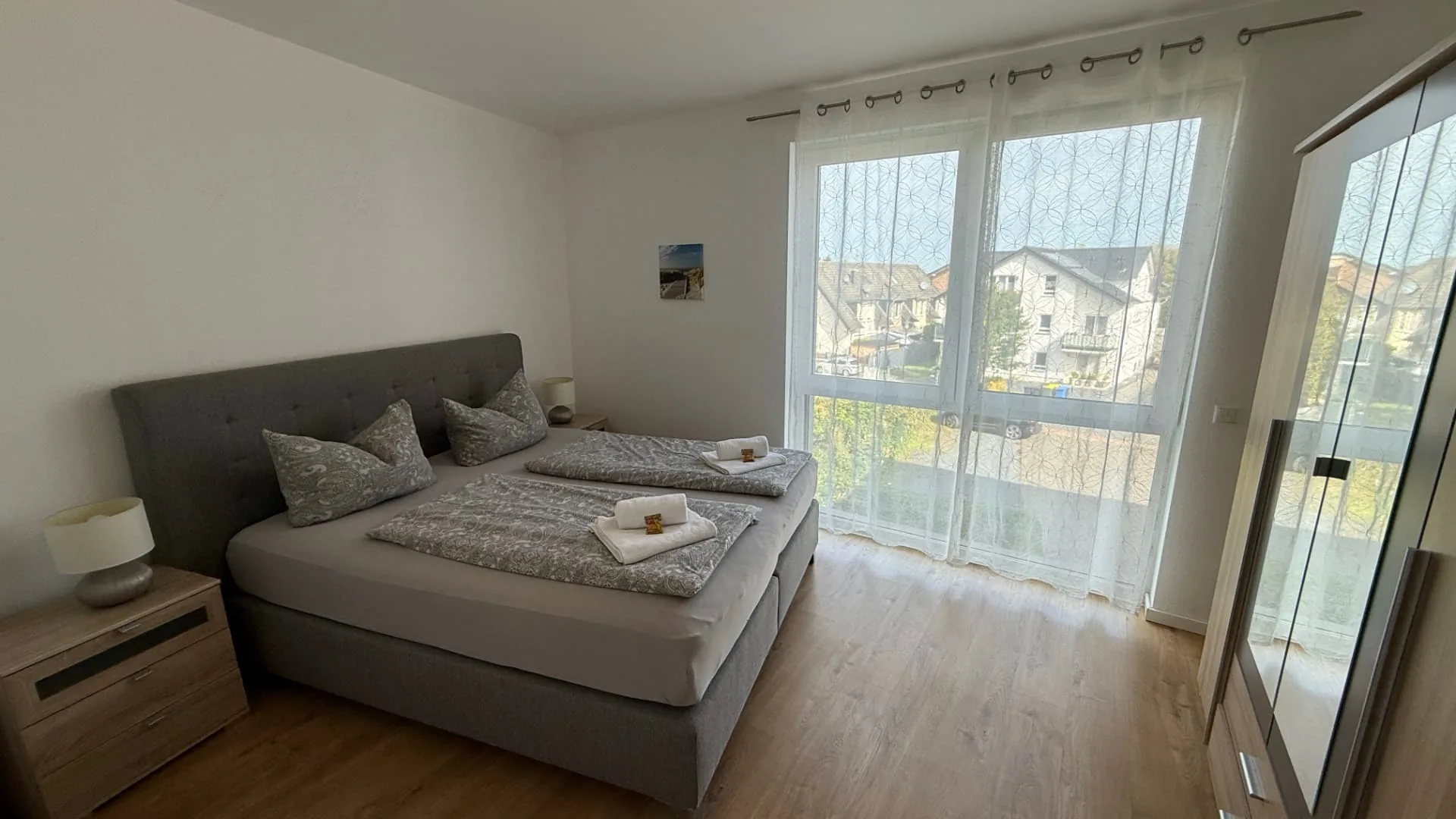 Schlafzimmer mit Boxspringbett und viel Tageslicht