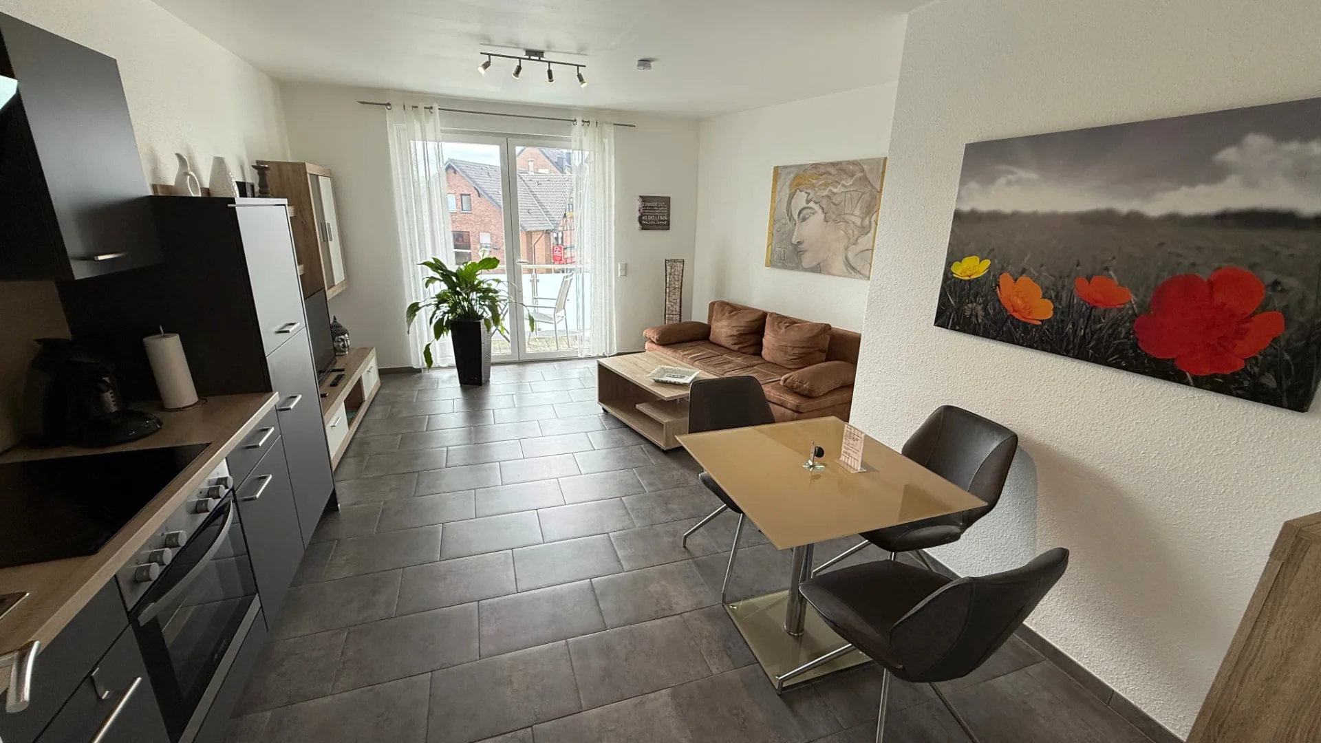 Wohn- und Essbereich mit Sofa, Esstisch und Balkonzugang im Cloud 7 Apartment