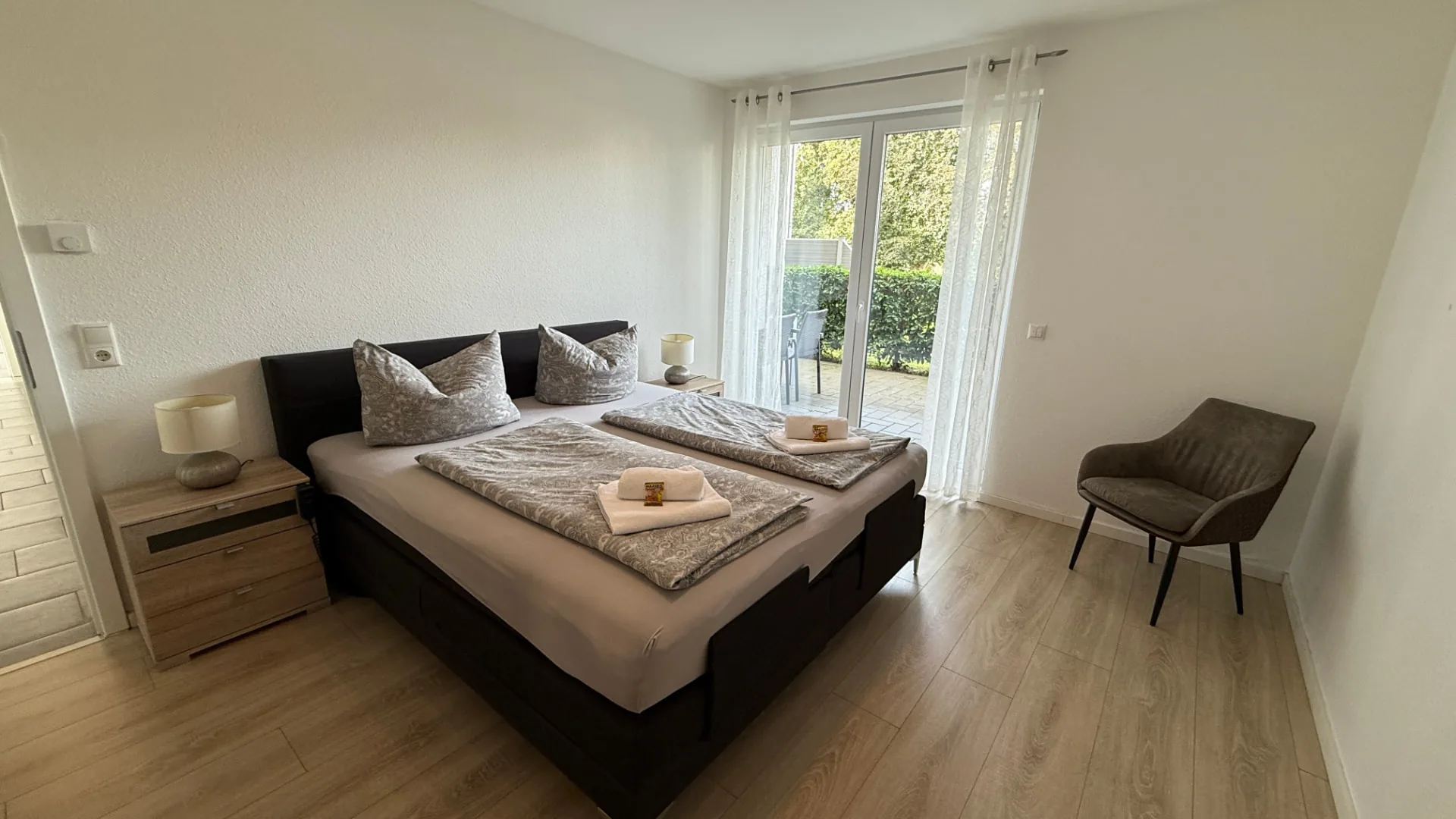 Schlafzimmer mit Doppelbett und Blick in den Garten